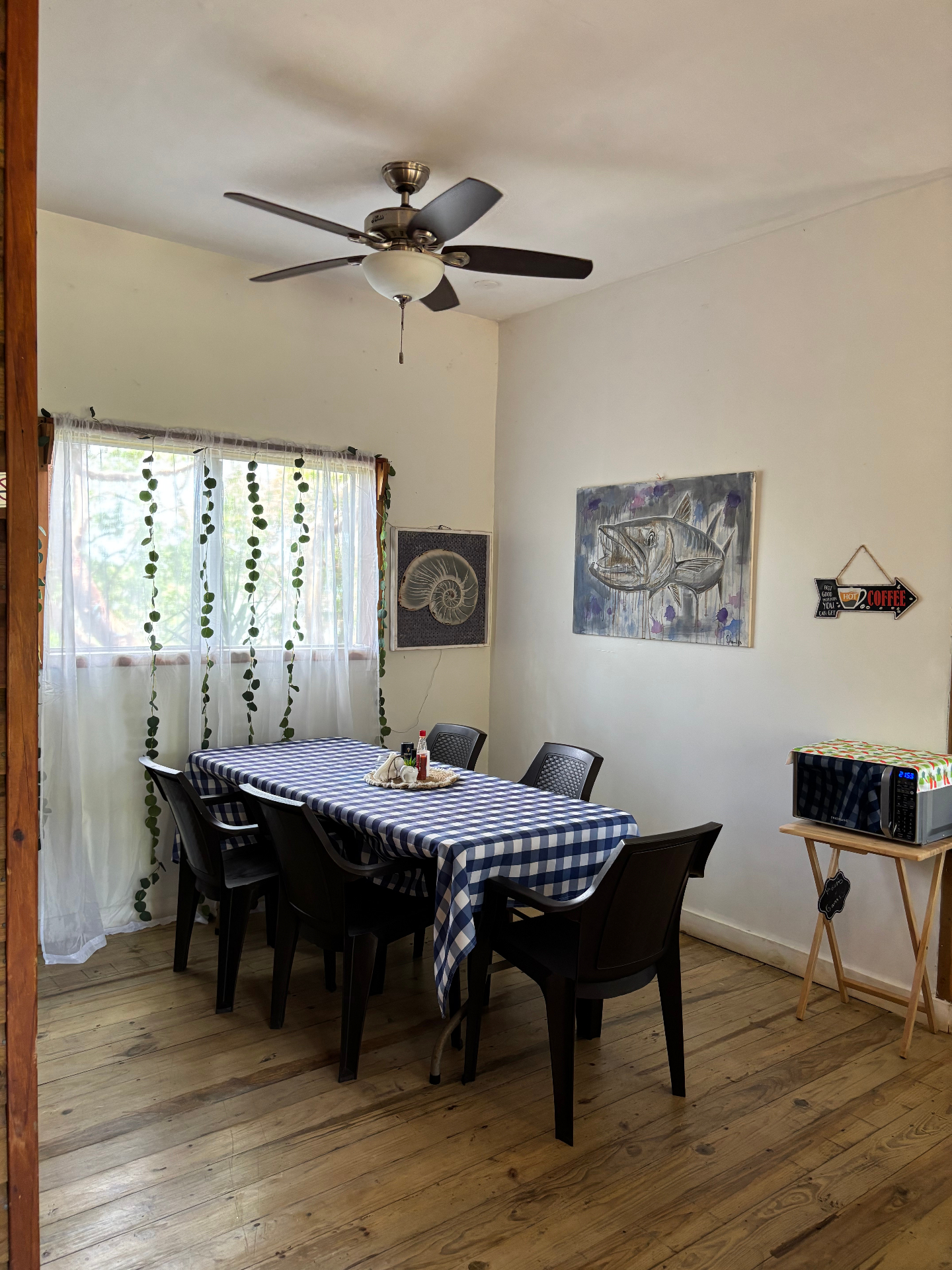 Quieter corner of the dining room — local art on the walls and morning light through the curtains.